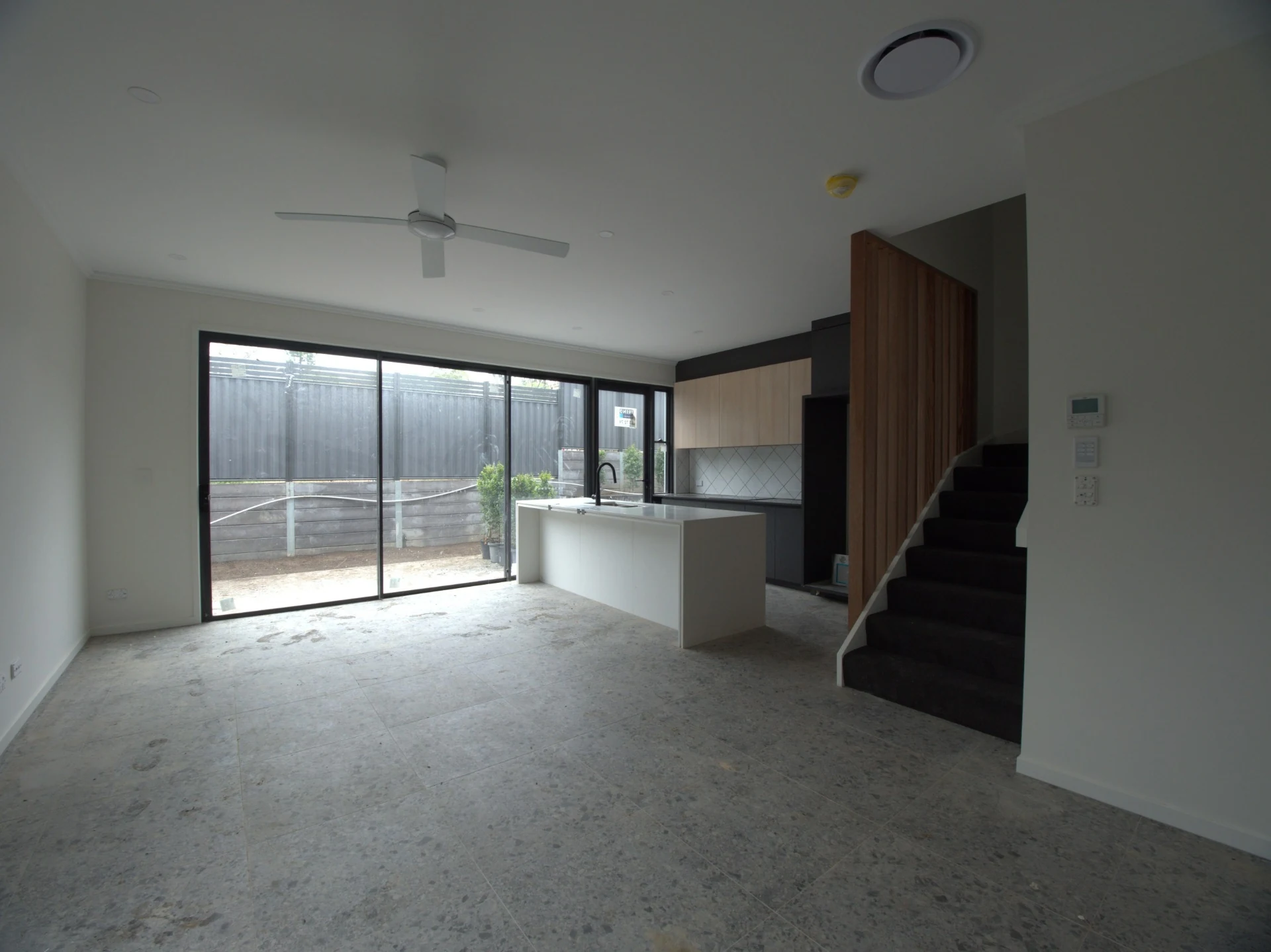 Before photo of bare living area with kitchen island